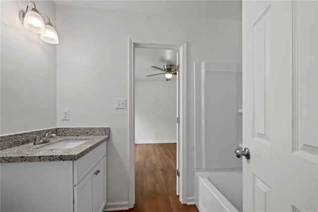 full bathroom featuring vanity, wood finished floors, baseboards, and ceiling fan