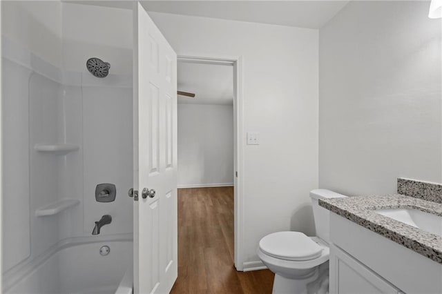 full bathroom featuring vanity, wood finished floors, baseboards, shower / bathing tub combination, and toilet