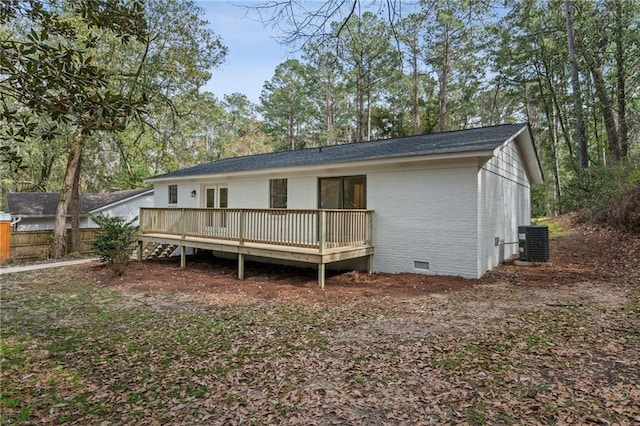 rear view of house with fence, central AC unit, crawl space, a deck, and brick siding