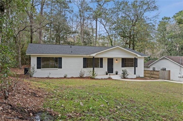 ranch-style home with a front yard, fence, and brick siding