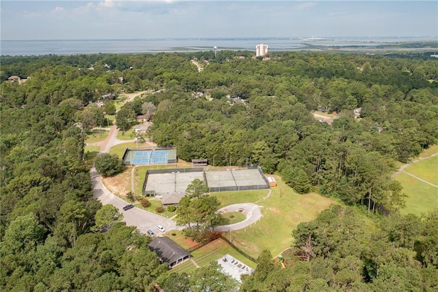 drone / aerial view with a forest view and a water view