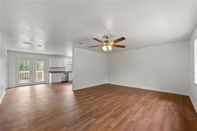 unfurnished living room featuring dark wood finished floors, visible vents, french doors, and baseboards