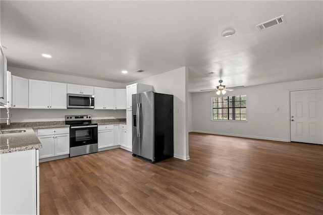 kitchen with visible vents, a sink, open floor plan, appliances with stainless steel finishes, and dark wood-style flooring