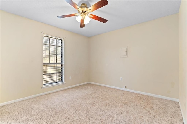 empty room with baseboards, a ceiling fan, and light colored carpet