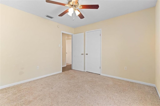 unfurnished bedroom with ceiling fan, light colored carpet, visible vents, and baseboards