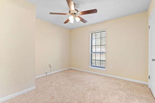 spare room with baseboards, a textured ceiling, a ceiling fan, and light colored carpet