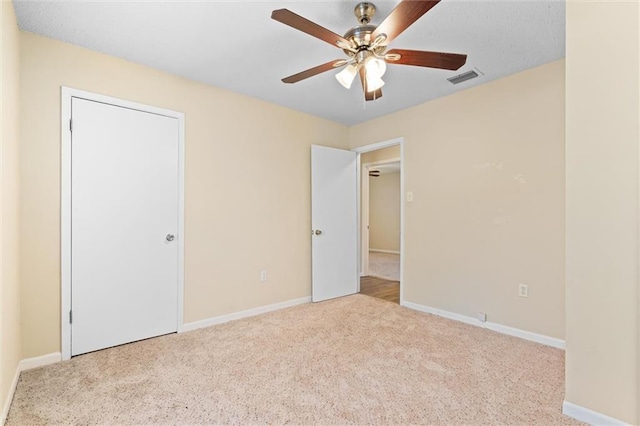 unfurnished bedroom featuring light colored carpet, visible vents, and baseboards