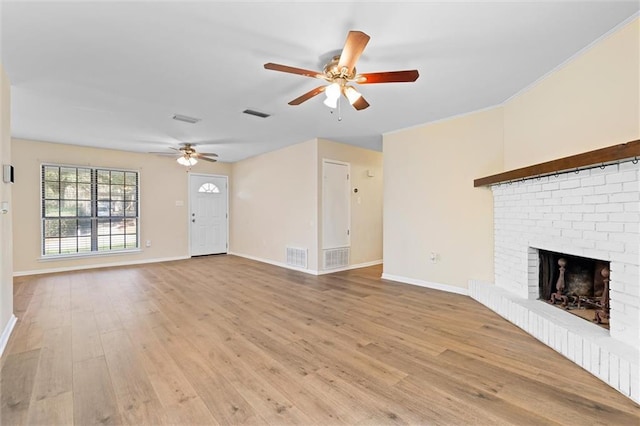 unfurnished living room with light wood-type flooring, a fireplace, visible vents, and baseboards