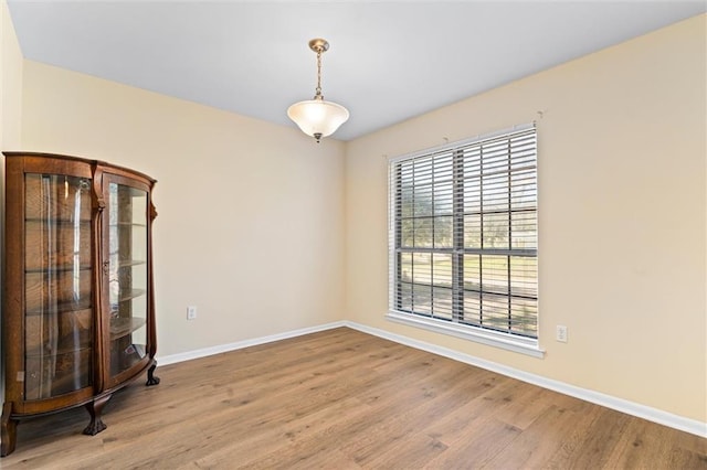 empty room with baseboards and light wood-style floors