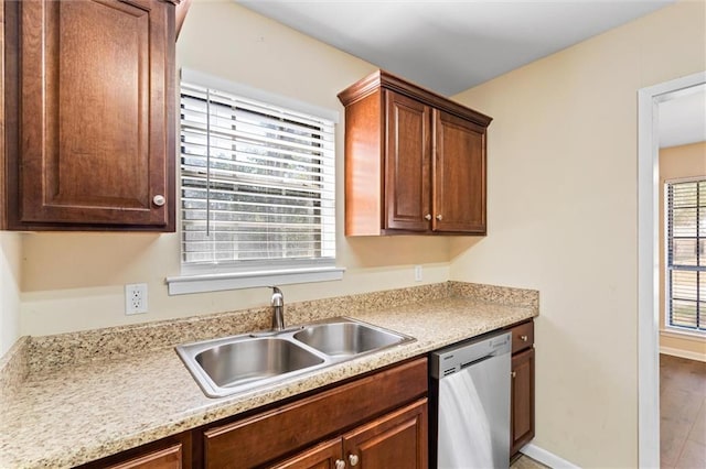 kitchen featuring a sink, baseboards, light countertops, and stainless steel dishwasher