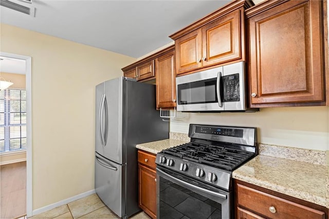 kitchen with visible vents, appliances with stainless steel finishes, brown cabinets, and baseboards