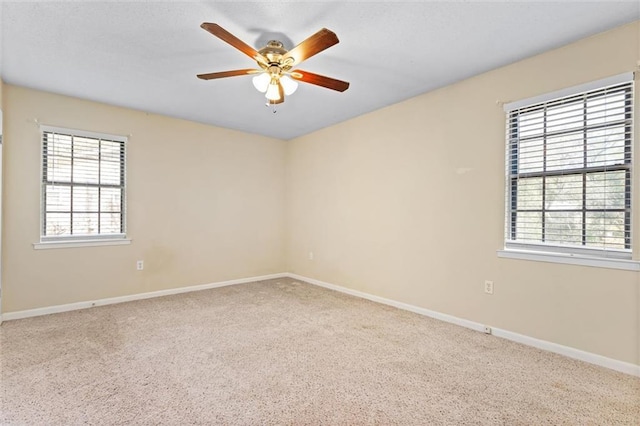 spare room with carpet, ceiling fan, and baseboards