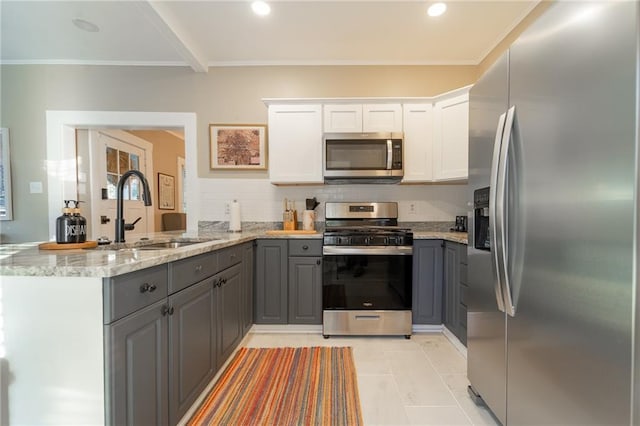 kitchen featuring gray cabinetry, sink, kitchen peninsula, white cabinets, and appliances with stainless steel finishes