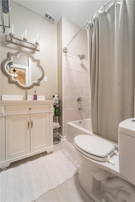 full bathroom with tile patterned floors, shower / tub combo with curtain, vanity, and toilet