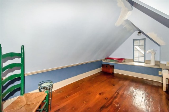 bonus room featuring dark wood-type flooring and vaulted ceiling