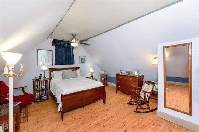 bedroom with ceiling fan, light hardwood / wood-style flooring, and vaulted ceiling