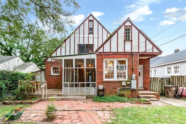 rear view of property with a sunroom and a patio area