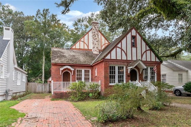 english style home featuring covered porch