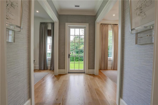 entryway with light hardwood / wood-style floors and ornamental molding