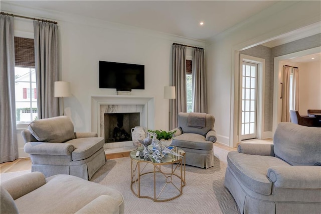 living room featuring crown molding, light hardwood / wood-style flooring, and a high end fireplace