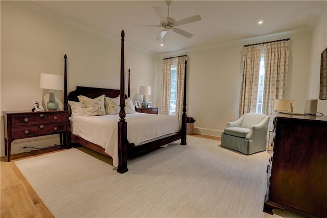 bedroom with multiple windows, light hardwood / wood-style flooring, and ceiling fan