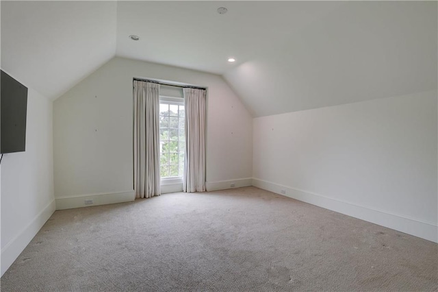 bonus room with light colored carpet and lofted ceiling