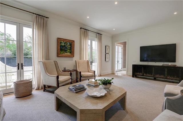 carpeted living room with a fireplace, french doors, crown molding, and a healthy amount of sunlight