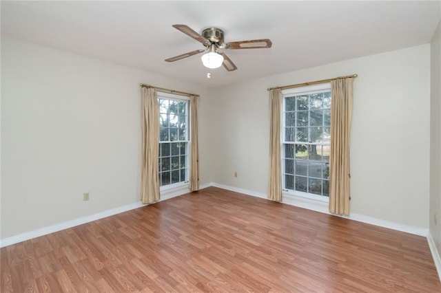 spare room with ceiling fan, a healthy amount of sunlight, and light wood-type flooring