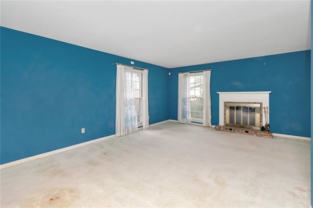 unfurnished living room featuring a brick fireplace and carpet floors