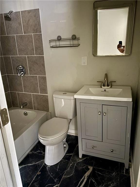 full bathroom featuring tiled shower / bath, vanity, and toilet