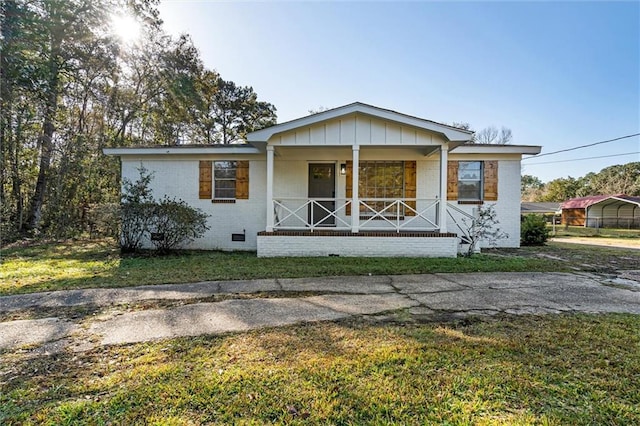 view of front of property featuring covered porch and a front lawn