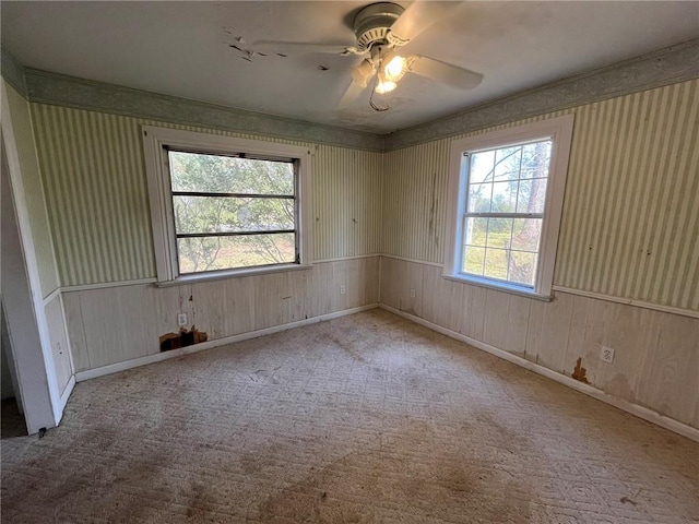 carpeted spare room featuring ceiling fan