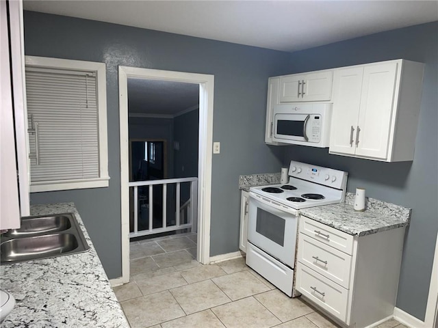 kitchen with white cabinets, sink, light tile patterned floors, white appliances, and light stone countertops