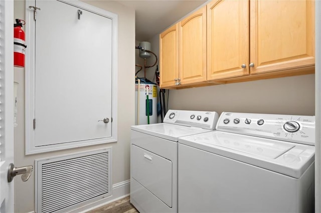 laundry area featuring cabinets, washer and clothes dryer, and electric water heater