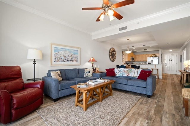 living room featuring ornamental molding, hardwood / wood-style floors, and ceiling fan