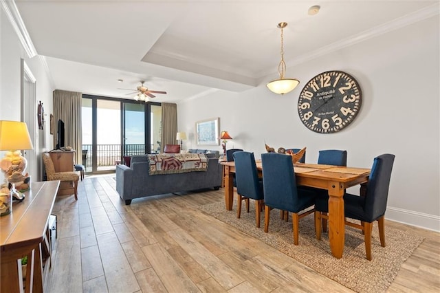 dining room with crown molding, floor to ceiling windows, ceiling fan, and light wood-type flooring