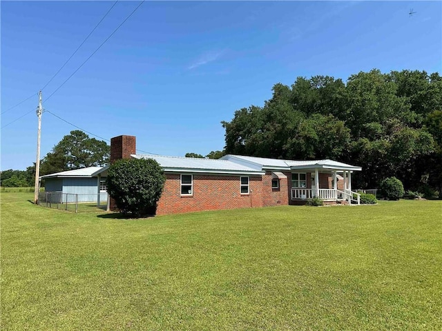 rear view of house featuring a lawn and a porch