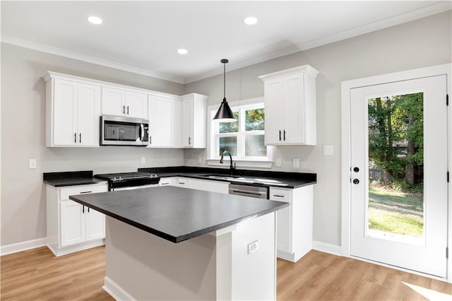 916 Mccay Ave, Mobile, AL 36609 - kitchen featuring stainless steel appliances, light wood finished floors, white cabinetry, dark countertops, and plenty of natural light