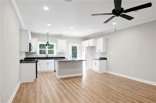 916 Mccay Ave, Mobile, AL 36609 - kitchen with appliances with stainless steel finishes, ornamental molding, dark countertops, light wood-type flooring, and ceiling fan