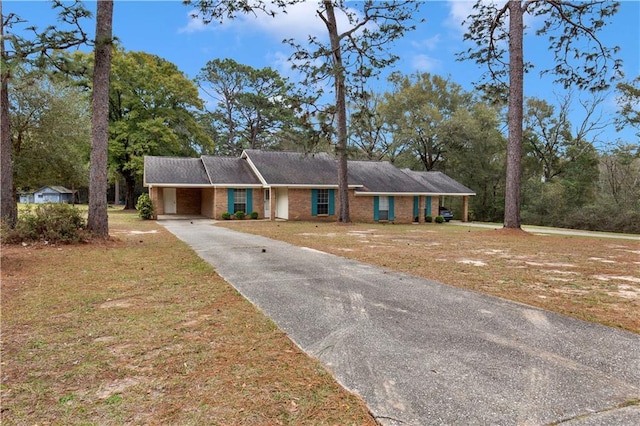 ranch-style house featuring aphalt driveway, a front yard, brick siding, and an attached carport