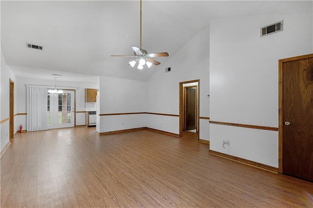 spare room with visible vents, light wood-style flooring, baseboards, and ceiling fan with notable chandelier