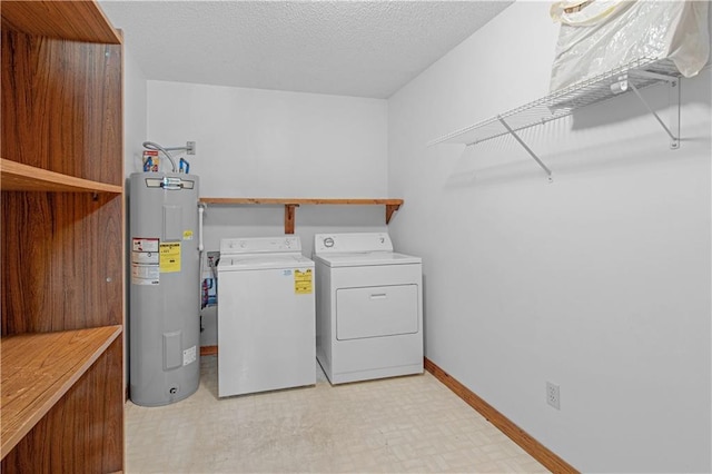 washroom with light floors, washing machine and dryer, electric water heater, a textured ceiling, and laundry area