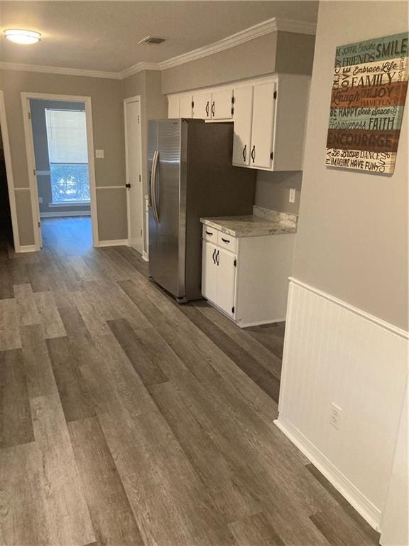 kitchen with ornamental molding, white cabinetry, stainless steel fridge, and dark hardwood / wood-style floors