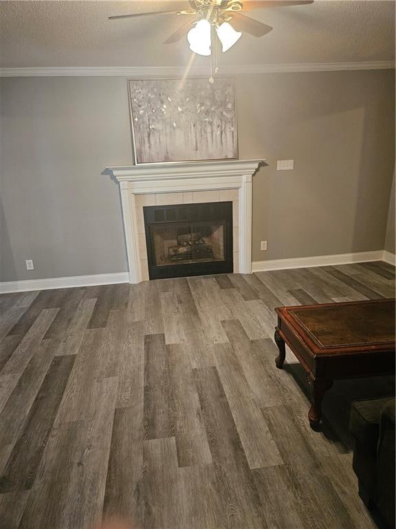 unfurnished living room with a textured ceiling, a tiled fireplace, wood-type flooring, and ceiling fan