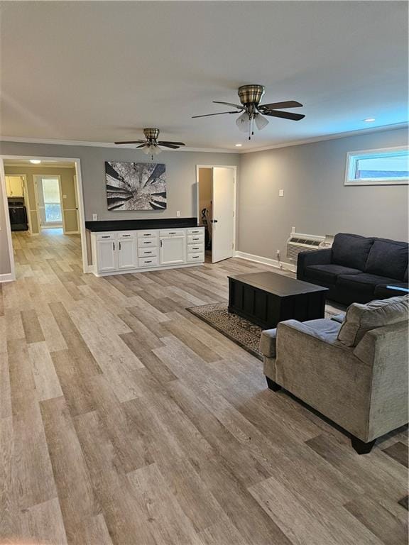 living room with light hardwood / wood-style floors, ornamental molding, and ceiling fan