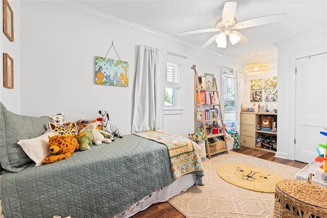 bedroom with ornamental molding, ceiling fan, and wood finished floors