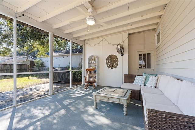 sunroom / solarium featuring beamed ceiling and ceiling fan