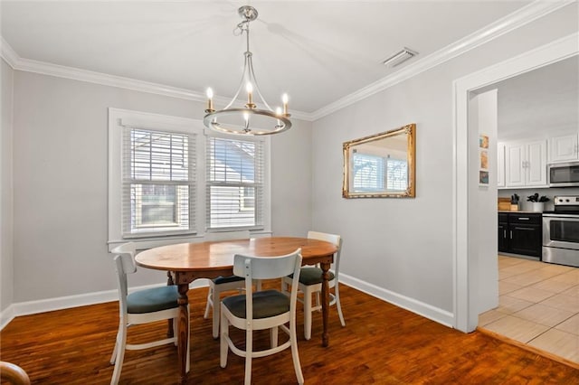 dining area with visible vents, crown molding, and light wood finished floors