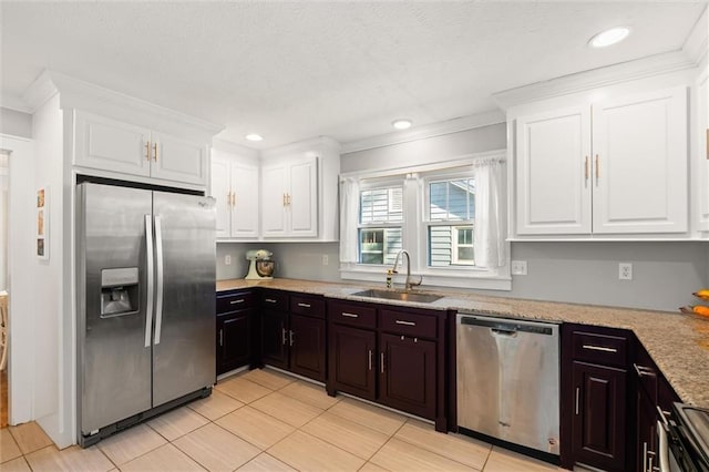 kitchen with a sink, appliances with stainless steel finishes, white cabinets, and ornamental molding