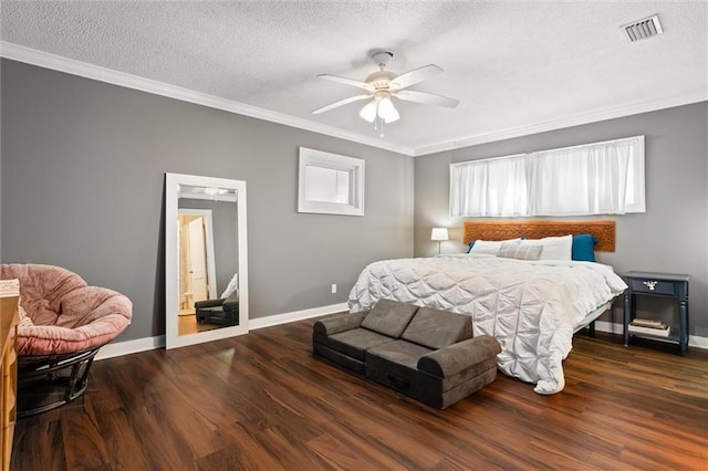 bedroom with wood finished floors, visible vents, baseboards, a textured ceiling, and crown molding